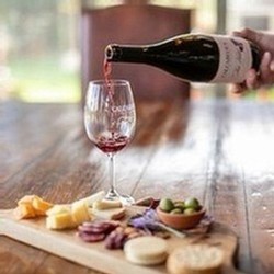 Pouring a glass of wine with a gourmet cheese plate at Calcareous Vineyard Winery in Paso Robles